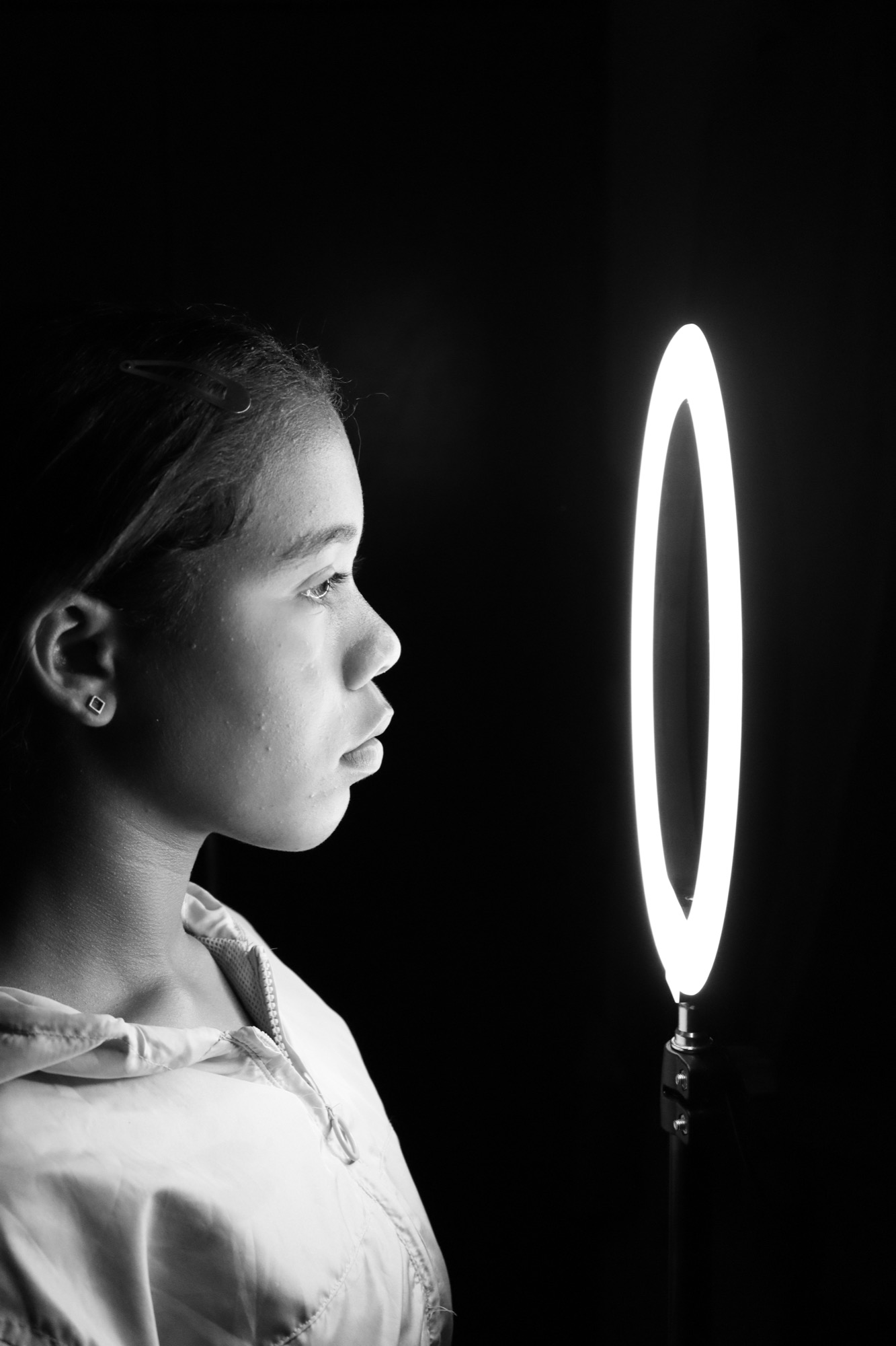 a girl with her face close to a ring of LEDs